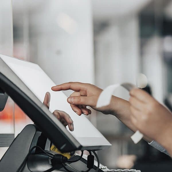 Empleado rellenando un ticket de venta en un ordenador