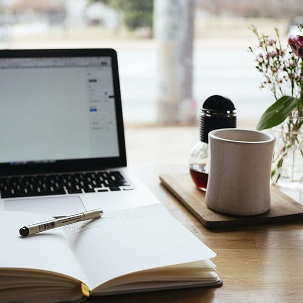 Escritorio con portátil, papeles y una taza de café