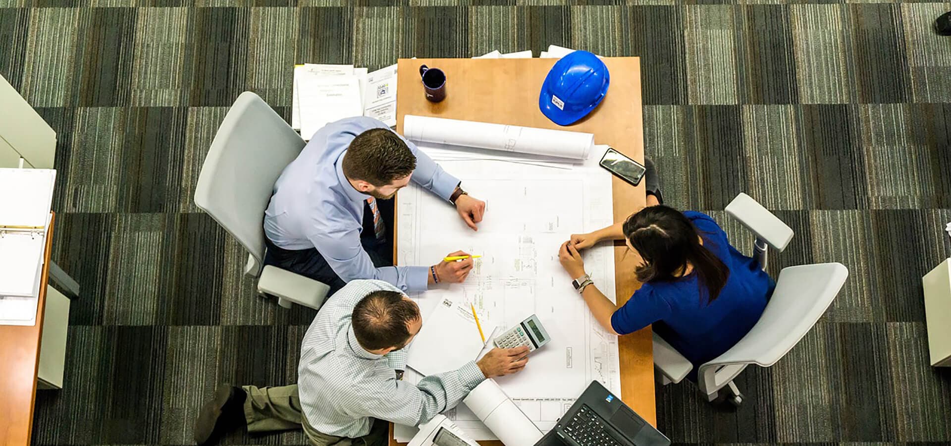 Tres persona trabajando sobre una mesa