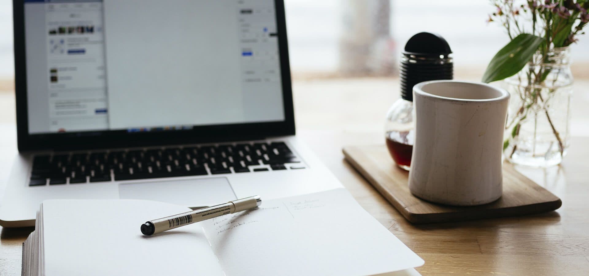 Escritorio con portátil, papeles y una taza de café